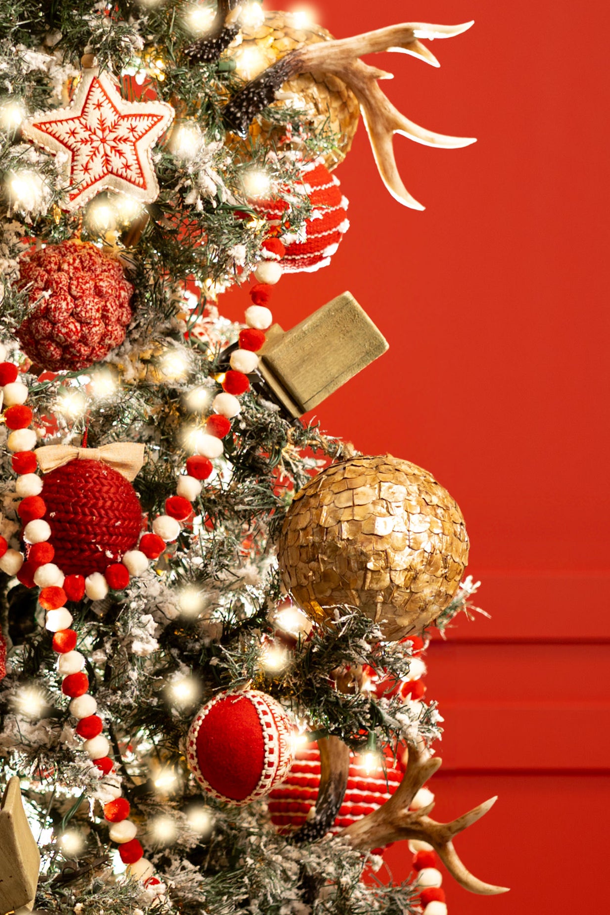 Retro Christmas decorations on reindeer tree - star ornaments, red and white Christmas garlands, gold ornaments, slays